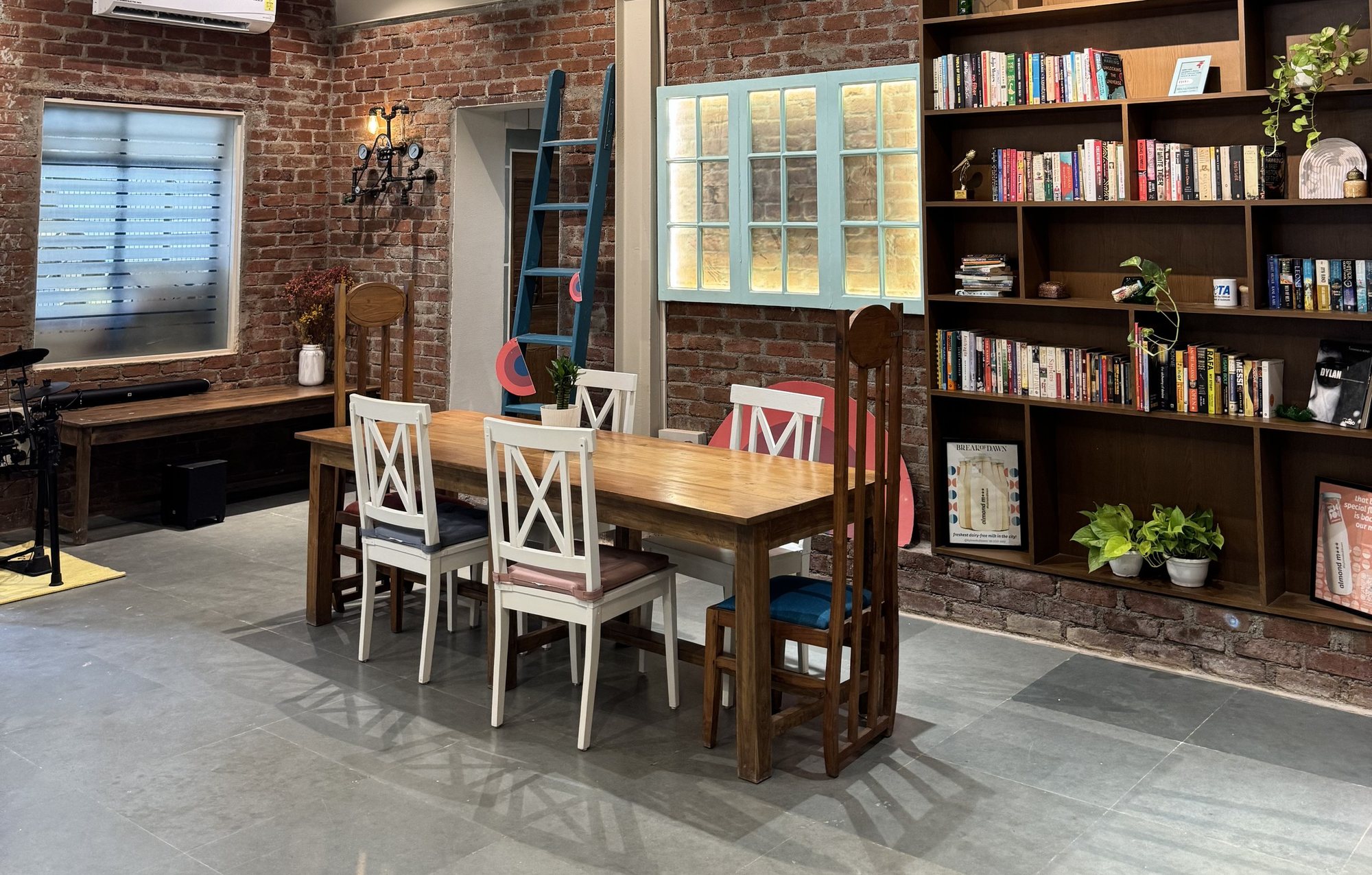The Gather studio by Break of Dawn: brick walls, bookshelves and a long communal table
