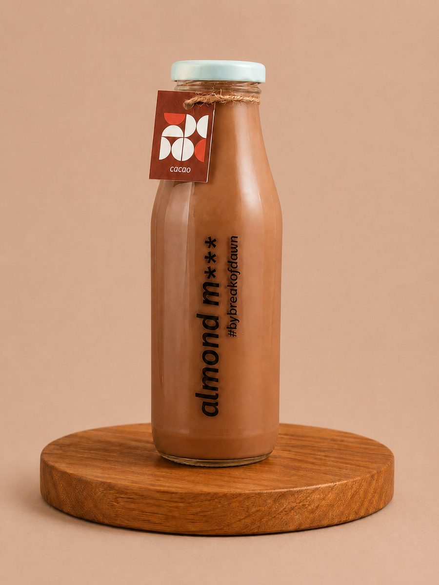 A glass bottle of Break of Dawn cacao almond milk, made fresh in Mumbai